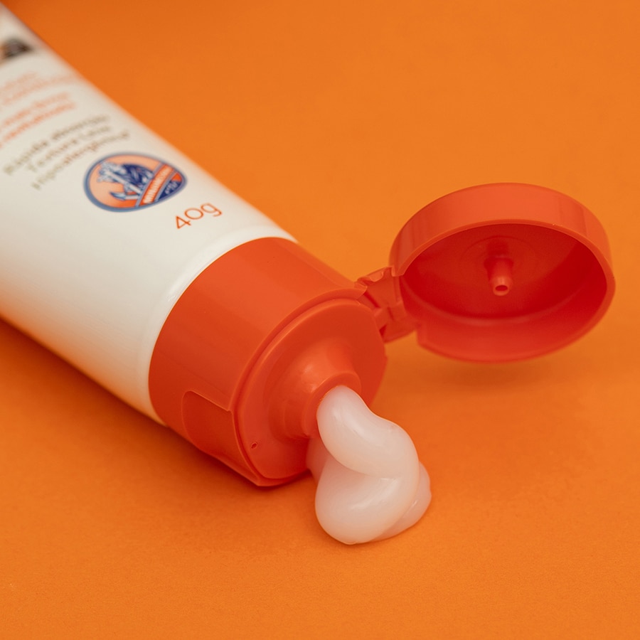 creme antissinais Minancora aberto com produto sendo aplicado.